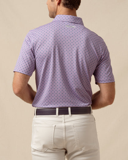 Back view of men’s haze purple polo with geometric medallion print tucked into light khaki pants
