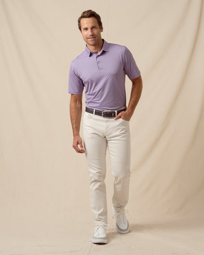 Men’s haze purple geometric print polo styled with light khaki pants, belt, and white sneakers