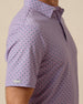 Close-up of men’s haze purple polo featuring a small-scale geometric medallion print and sleeve logo detail