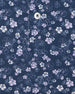 Men's Dogwood Polo in New Indigo, close-up flat lay view featuring a navy fabric with an all-over scattered floral blossom print in lavender and white with a visible button placket and chest pocket detail