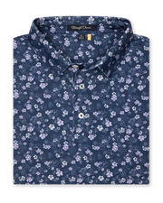 Men's Dogwood Polo in New Indigo, folded flat lay front view featuring an allover floral dogwood blossom print in lavender and white on a navy base