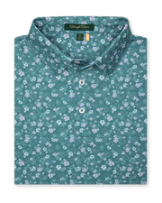 Men's Dogwood Polo in Sage, folded flat lay front view featuring an allover floral dogwood blossom print in lavender and white on a teal green base