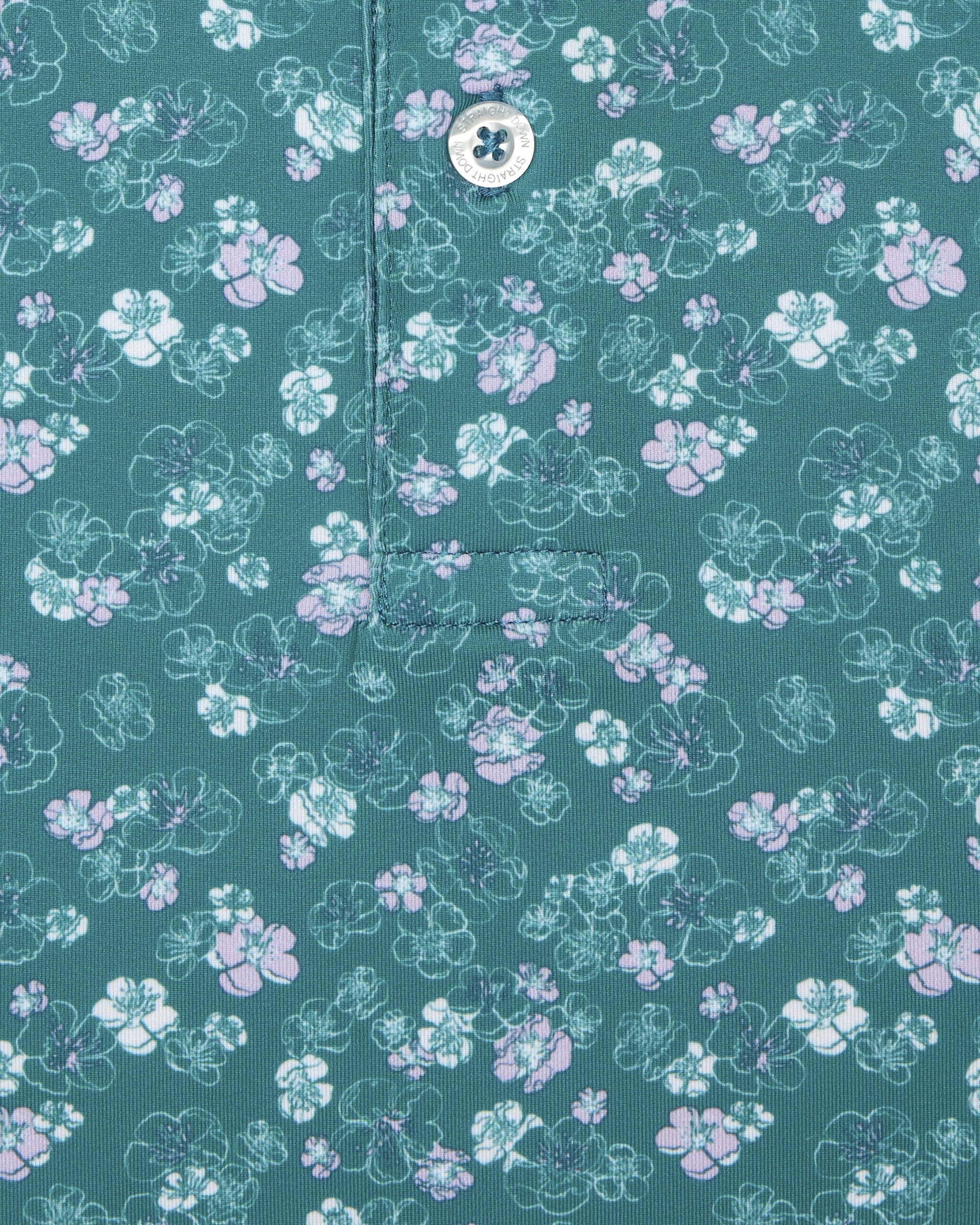 Men's Dogwood Polo in Sage, close-up detail view featuring scattered white and lavender floral print and Straight Down logo engraved button with placket detail