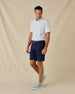 Model wearing the South Beach Polo in Blue Shade with navy golf shorts, a coordinating belt, and gray sneakers.