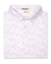 Men's South Beach Polo in Violet, folded flat lay front view featuring a white short sleeve polo with an all-over scenic print of palm trees, flamingos, and buildings in pink and lavender