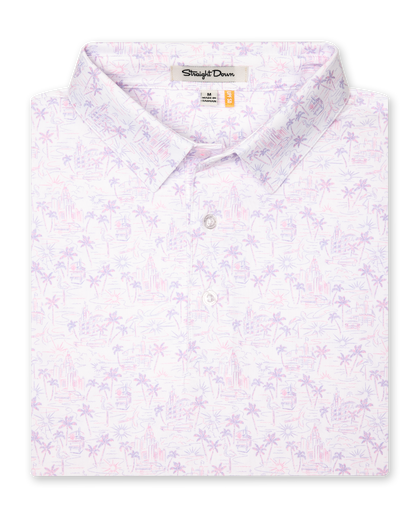 Men's South Beach Polo in Violet, folded flat lay front view featuring a white short sleeve polo with an all-over scenic print of palm trees, flamingos, and buildings in pink and lavender