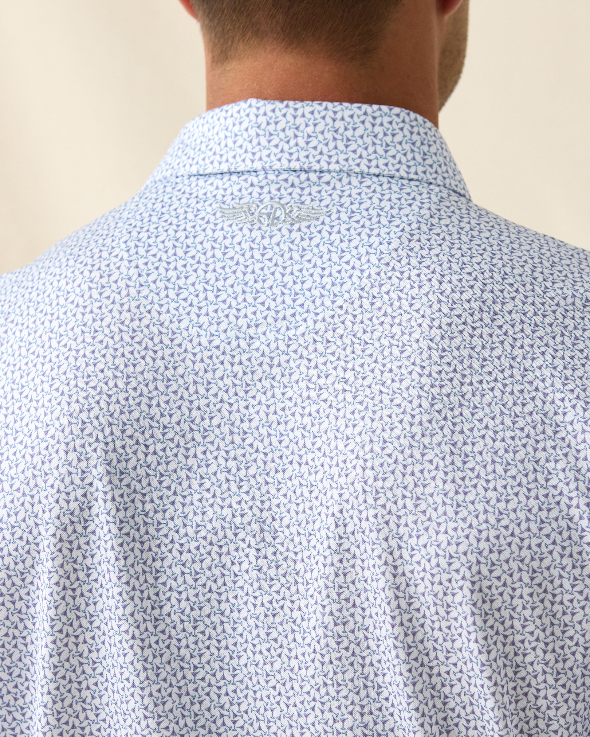 Men's Gin Therapy Polo in Pink Floyd, close-up back neck detail featuring the Straight Down logo embroidered at center back and an allover martini glass print in purple and light blue