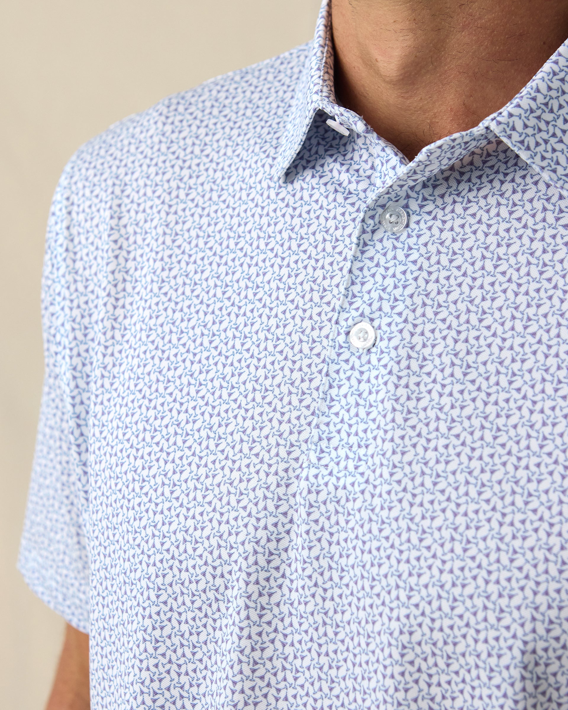 Men's Gin Therapy Polo in Pink Floyd, close-up front chest detail featuring two-button placket and an allover martini glass print in purple and light blue on white