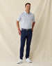 Men's Gin Therapy Polo in Pink Floyd, full length front view on model featuring an allover martini glass print in purple and light blue on white, paired with navy pants, a navy belt, and white golf shoes