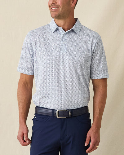 Men's Gin Therapy Polo in Pink Floyd, front view on model featuring an allover martini glass print in purple and light blue on white, paired with navy pants and a navy belt
