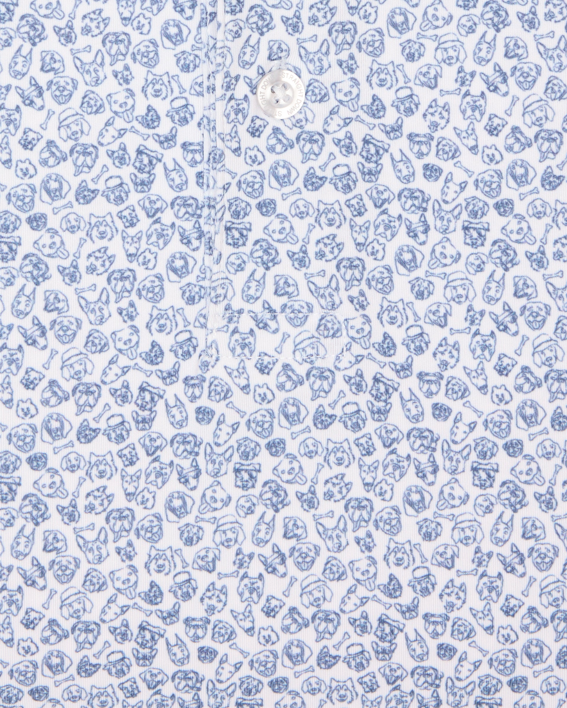 Men's Dog Pound Polo in Moonlight, close-up flat lay view featuring a white fabric with an all-over scattered dog face and bone print in navy with a visible button placket detail