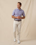 Men’s light purple floral print polo shirt paired with light khaki pants, belt, and white sneakers
