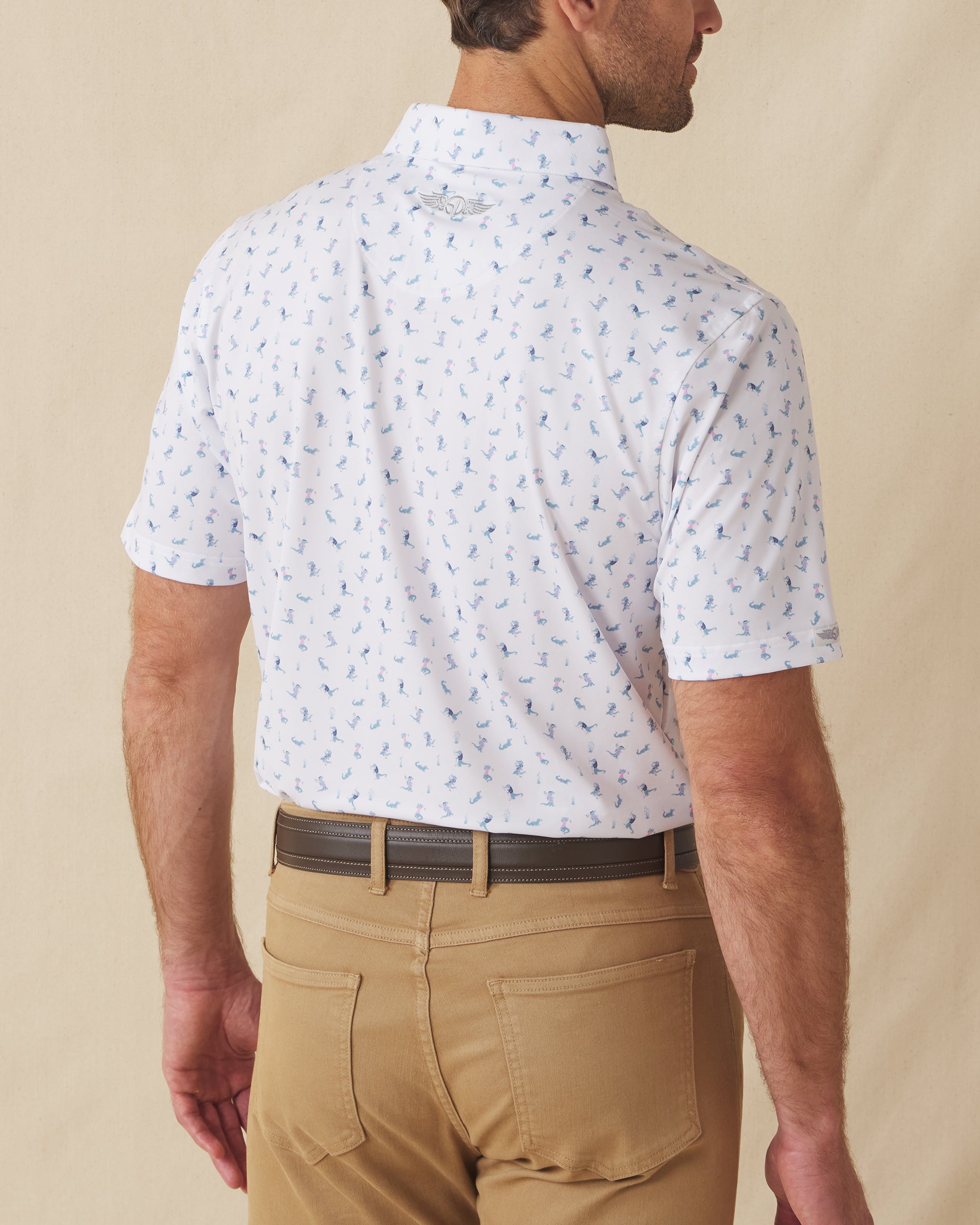Men's Gators Polo in Violet, back model view featuring a white short sleeve polo with an all-over scattered golf-playing alligator print in blue and pink with the Straight Down logo at the back collar