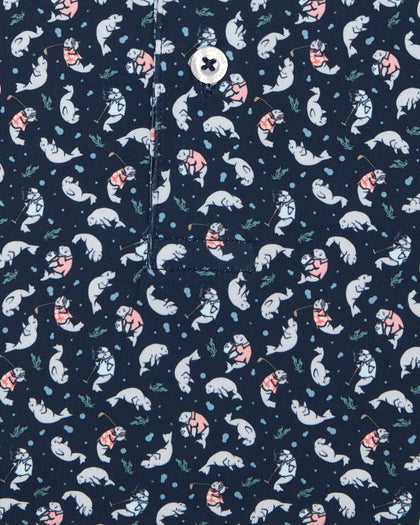 Men's Manatee County Polo in New Indigo, close-up flat lay view featuring a navy fabric with an all-over scattered golf-playing manatee print in white and pink with a visible button placket detail