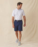 Men's Golden State Polo in Spritz, full length front view on model featuring a white base with an all-over blue and pink California landscape sketch print, paired with navy shorts, a dark leather belt, and gray shoes