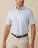 Men's Slam Dunk Polo in Coastal, front view on model featuring an allover basketball hoop and ball print in light blue and pink on white, paired with khaki pants and a brown belt