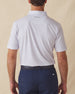 Men's Cocora Polo in Coastal, back view on model featuring a white base with an all-over blue and pink palm tree micro print, with Straight Down logo embroidered at upper back, paired with navy pants
