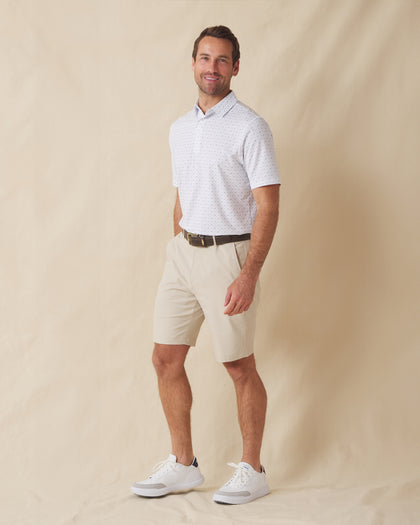 Men's Livingston Polo in White, full length front view on model featuring a white base with a scattered navy and light blue seagull print, paired with khaki shorts, a dark leather belt, and white shoes
