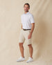 Men's Livingston Polo in White, full length front view on model featuring a white base with a scattered navy and light blue seagull print, paired with khaki shorts, a dark leather belt, and white shoes