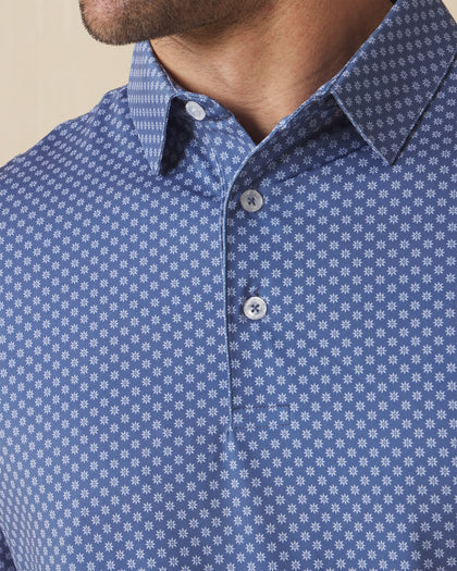 Close-up of blue polo collar and placket with geometric floral pattern and button detail
