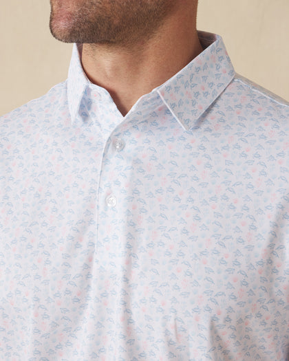 Men's Turtle Island Polo in Coastal, collar detail view featuring an allover sea turtle and coral print in light blue and pink tones on a white performance fabric