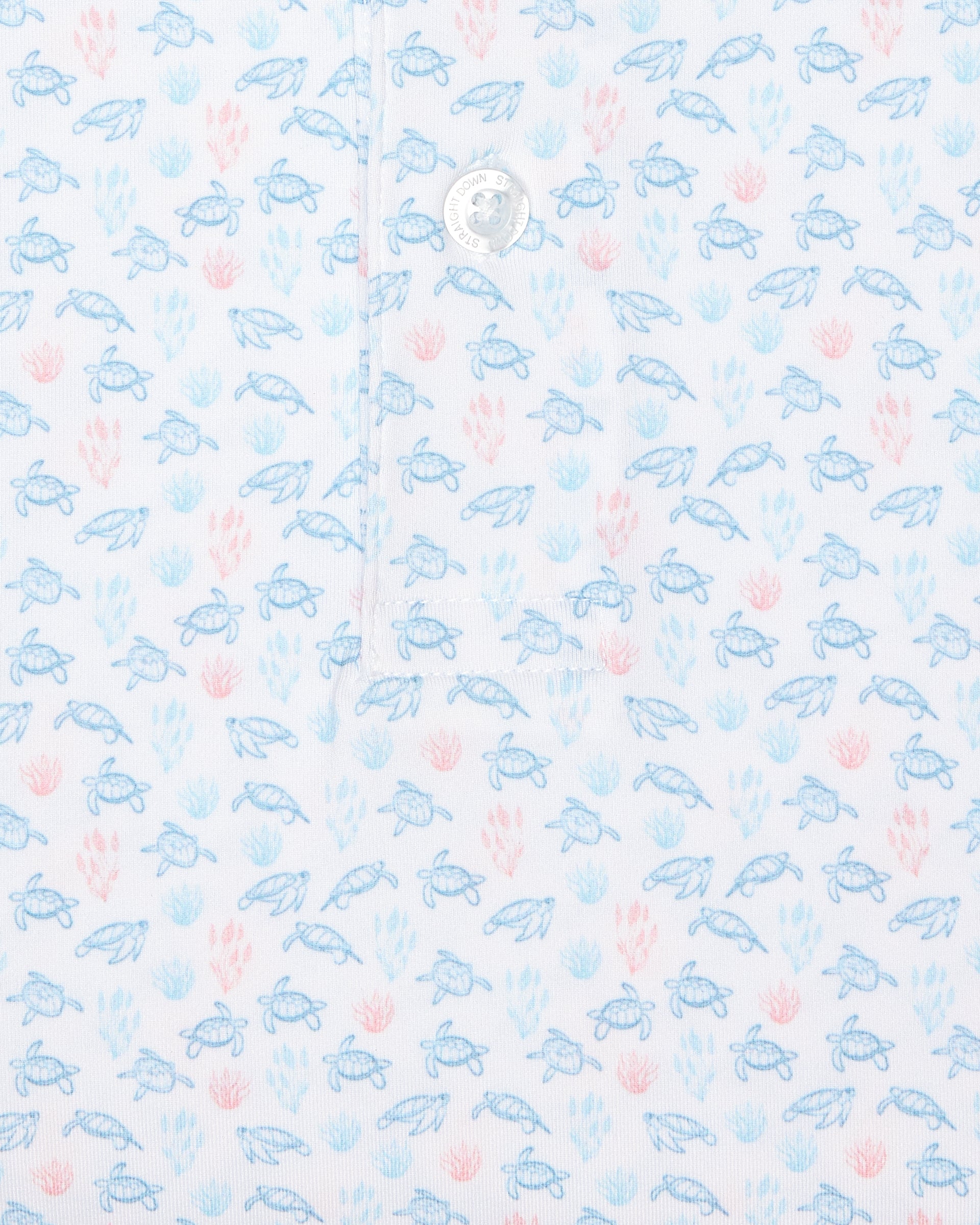 Men's Turtle Island Polo in Coastal, close-up fabric detail view featuring an allover sea turtle and coral print in light blue and pink tones on a white performance fabric