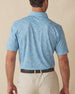 Men's Ka'anapali Polo in Coastal, back model view featuring a medium blue short sleeve polo with an allover white tropical floral and palm leaf line-art print, with an embroidered Straight Down logo at the back collar