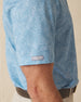 Men's Ka'anapali Polo in Coastal, sleeve detail view featuring a medium blue short sleeve polo with an allover white tropical floral and palm leaf line-art print, with a Straight Down logo tab on the sleeve hem