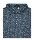 Men's Redbud Polo in New Indigo, folded flat lay front view featuring a navy base with a scattered green and light pink floral print