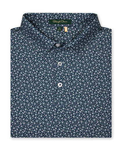 Men's Redbud Polo in New Indigo, folded flat lay front view featuring a navy base with a scattered green and light pink floral print