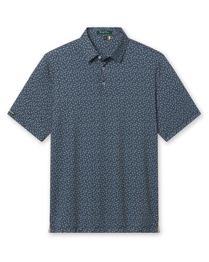 Men's Redbud Polo in New Indigo, flat lay front view featuring a navy base with a scattered green and light pink floral print and Straight Down sleeve tab