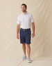 Men's Pimento Cheese Polo in White, full length front view on model featuring a white base with a scattered golf, sandwich, and drink print in purple, teal, and orange