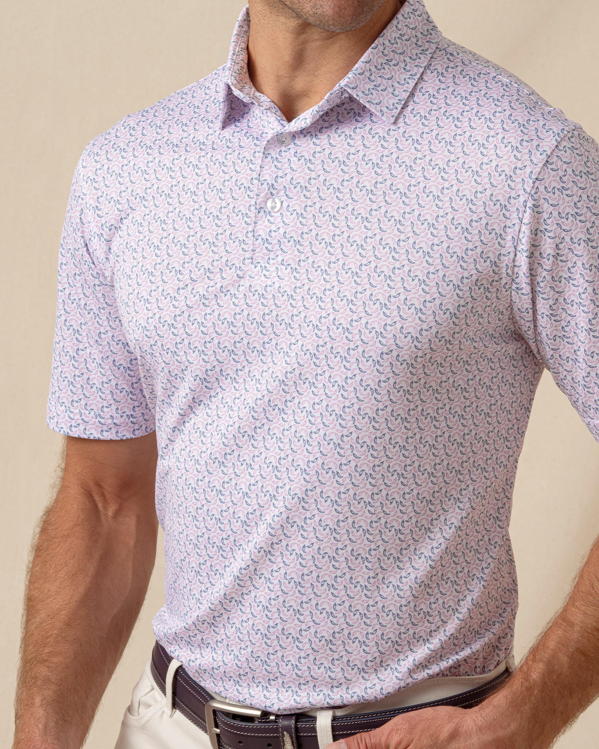 Close-up of light pink polo with small chili pepper pattern and structured collar