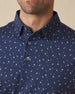 Close-up of navy polo shirt with martini print and button placket detail