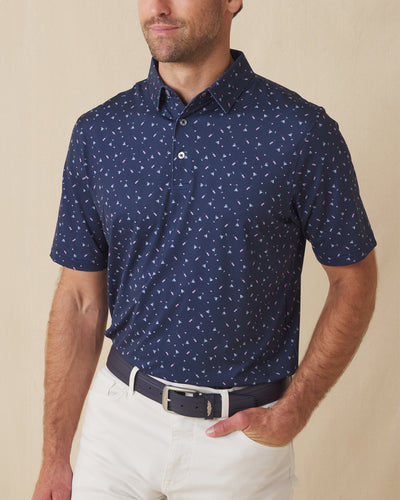 Men’s navy martini print polo shirt worn with light pants, front view