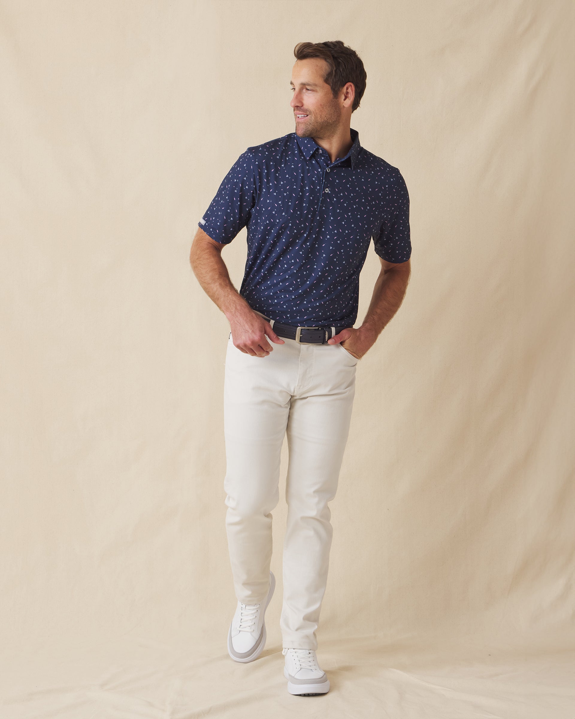 Men’s navy martini print polo shirt styled with light pants and white sneakers