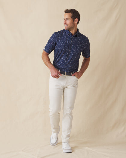 Men’s navy martini print polo shirt styled with light pants and white sneakers