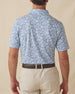 Men's Lihu'e Polo in Sea Spray, back model view featuring a light blue short sleeve polo with an allover navy hibiscus flower and monstera leaf print, with an embroidered Straight Down logo at the back collar