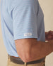 Men's Channel Stripe Polo in Coastal, sleeve detail view featuring a light blue short sleeve polo with horizontal pink and white stripes, with a Straight Down logo tab on the sleeve hem