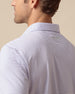 Back shoulder detail of lilac striped polo with embroidered logo below the collar