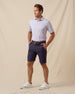 Men’s lilac striped polo paired with navy shorts, brown belt, and white sneakers