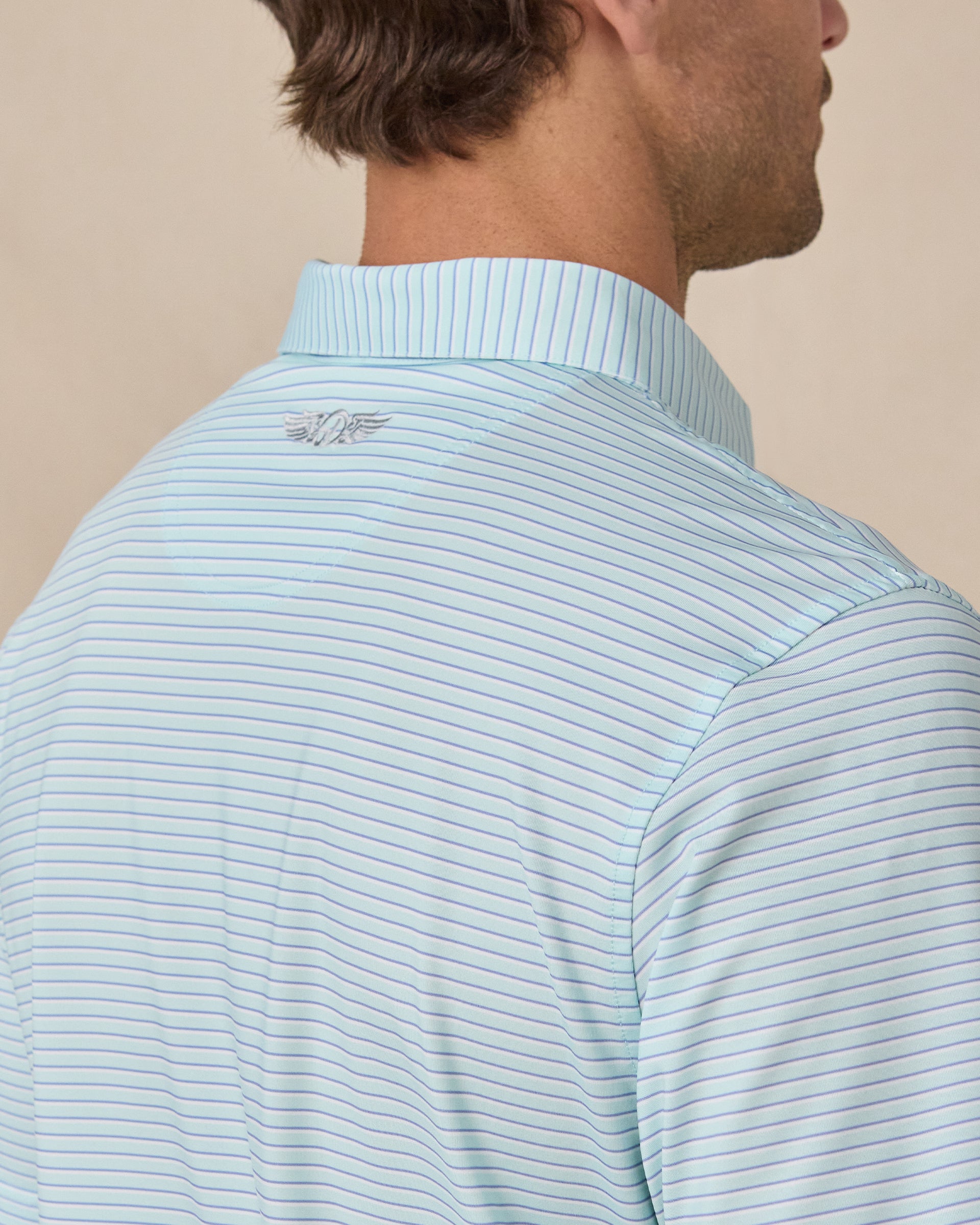 Close-up of the back shoulder on the Men's Channel Stripe Golf Polo in Mint Tea, highlighting the embroidered Straight Down logo and fine stripe pattern.