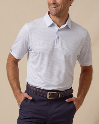 Men’s light blue shark print performance polo paired with navy shorts and a leather belt