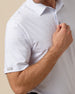 Close-up of men’s light blue shark print performance polo sleeve with subtle logo detail