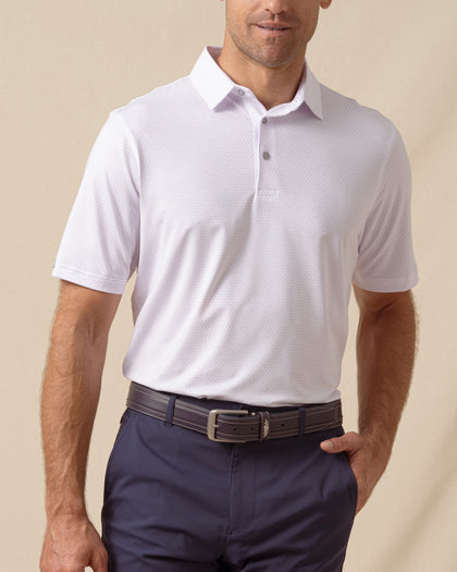 Men’s lilac performance polo featuring a subtle ace-of-spades print, worn with navy shorts