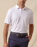 Men’s lilac performance polo featuring a subtle ace-of-spades print, worn with navy shorts