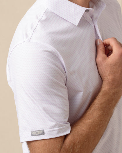 Close-up of men’s lilac performance polo with subtle ace-of-spades print and sleeve logo detail