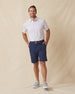 Men's Preserve Stripe Polo in Spritz, full length model view featuring a white short sleeve polo with horizontal pink and blue pinstripes, styled with navy shorts and gray shoes