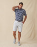 Men's Pineapple Express Polo in New Indigo, full-length front view on model featuring a navy and white pineapple print, styled with light grey shorts and grey shoes