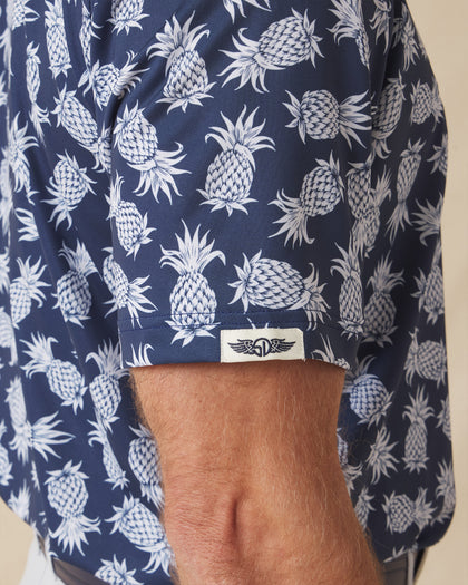 Men's Pineapple Express Polo in New Indigo, close-up detail view of the sleeve hem featuring the Straight Down logo label and navy and white pineapple print